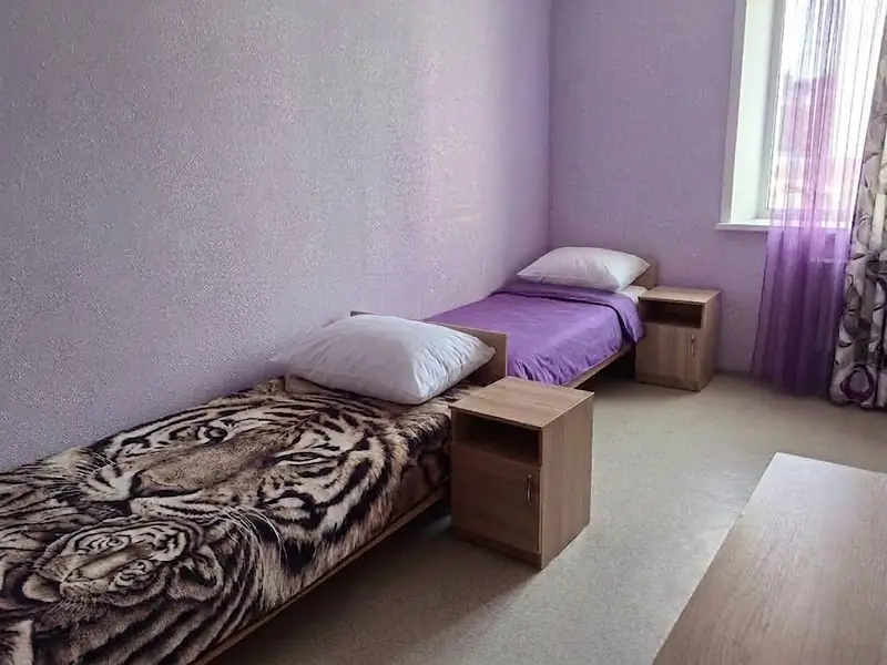 Кровати с тумбочками в комнате VIP-квартиры