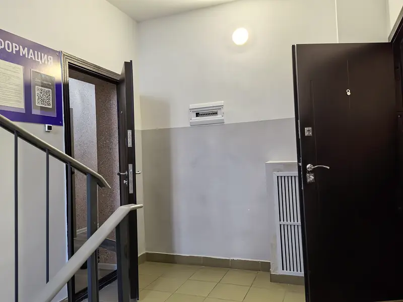 Лестничная площадка, информационный стенд и вход на этаж